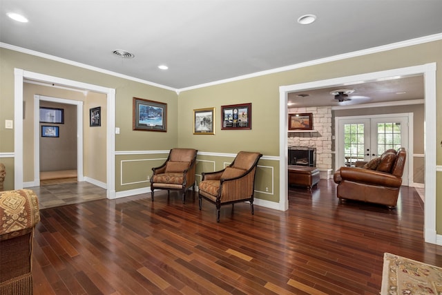 sitting room with a stone fireplace, french doors, crown molding, and hardwood / wood-style flooring