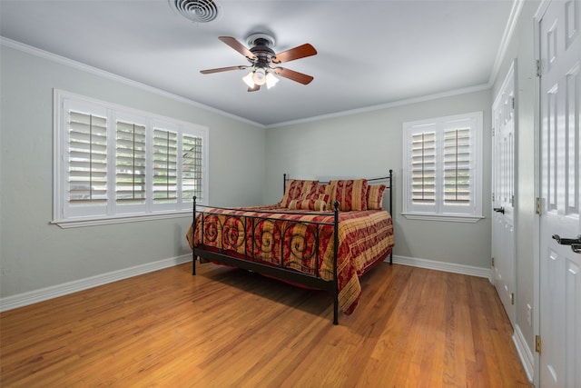 bedroom featuring ceiling fan, multiple windows, and light hardwood / wood-style floors