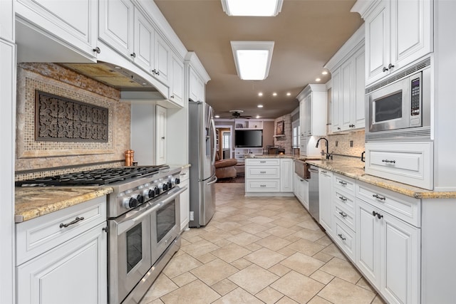 kitchen featuring decorative backsplash, white cabinets, and appliances with stainless steel finishes