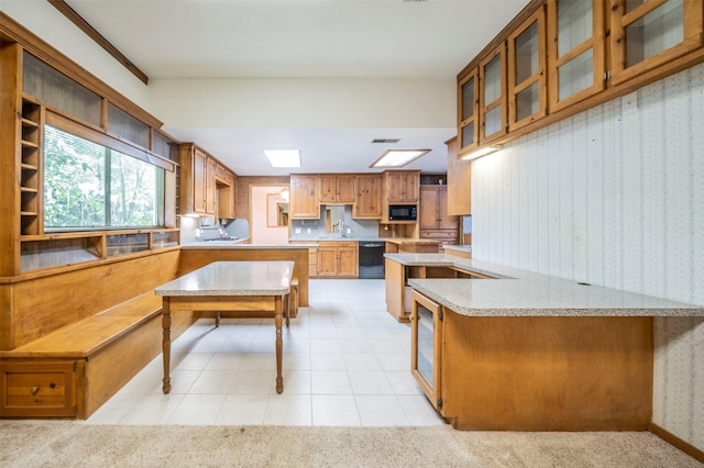 kitchen featuring sink, kitchen peninsula, black appliances, and light colored carpet