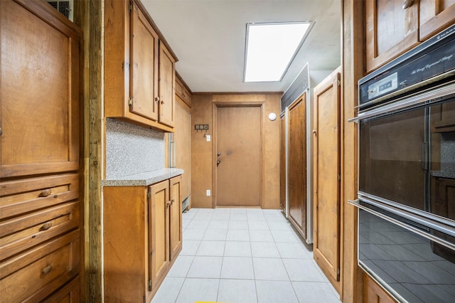 kitchen featuring double oven and light tile patterned floors