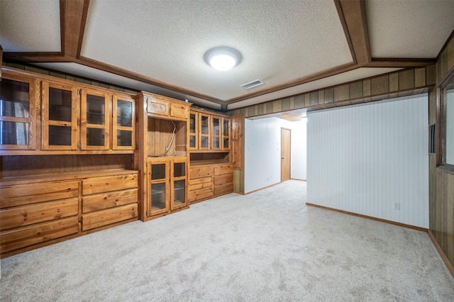 interior space with a textured ceiling, vaulted ceiling, and carpet flooring