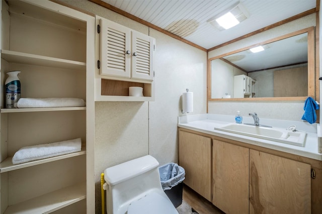 bathroom featuring ornamental molding, vanity, and toilet