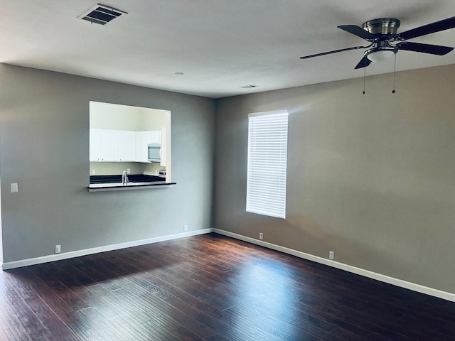 unfurnished living room with sink, ceiling fan, and hardwood / wood-style floors