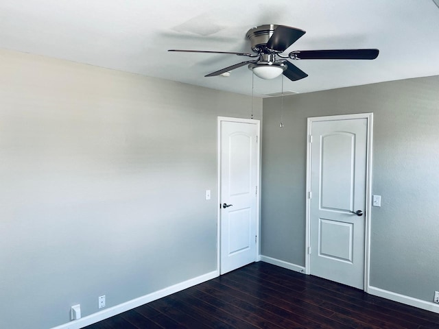 empty room featuring dark hardwood / wood-style flooring and ceiling fan