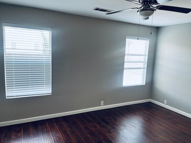 spare room featuring a healthy amount of sunlight, wood-type flooring, and ceiling fan