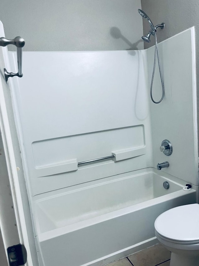 bathroom featuring shower / bath combination, tile patterned flooring, and toilet