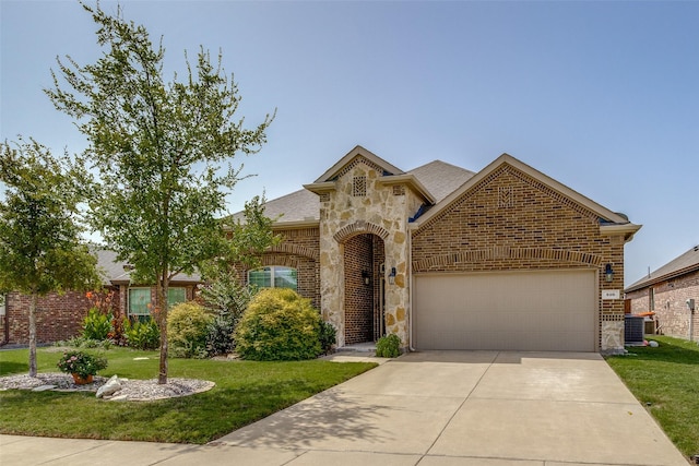 view of front of property with a garage, central AC unit, and a front lawn