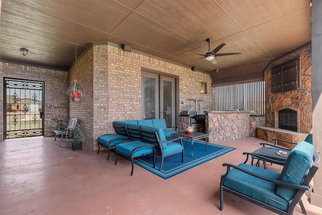 view of patio with an outdoor living space with a fireplace and ceiling fan