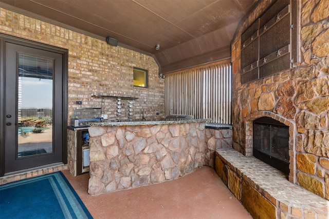 view of patio featuring an outdoor stone fireplace