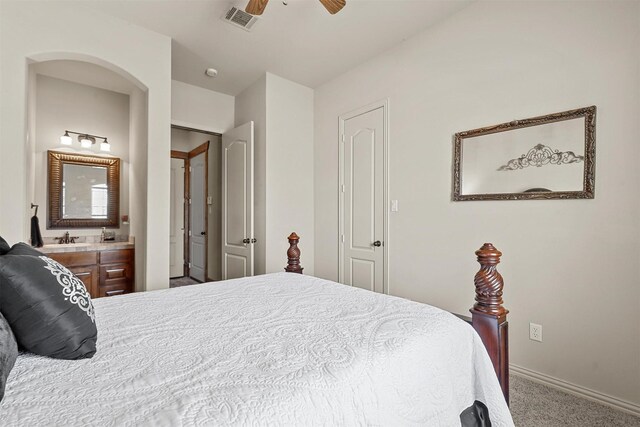 bedroom with connected bathroom, carpet, and ceiling fan