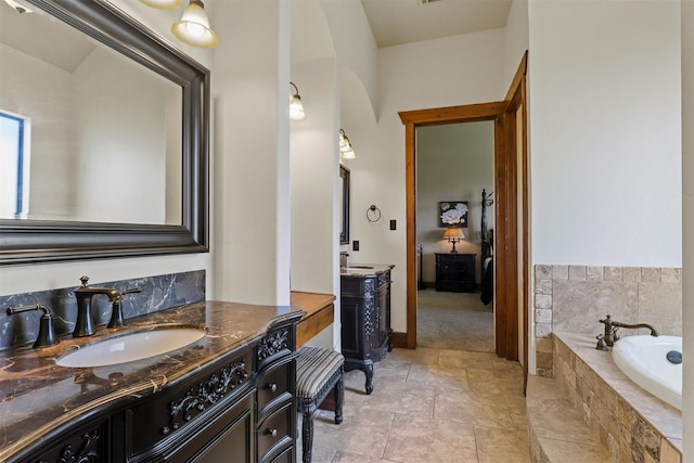 bathroom featuring vanity and tiled tub