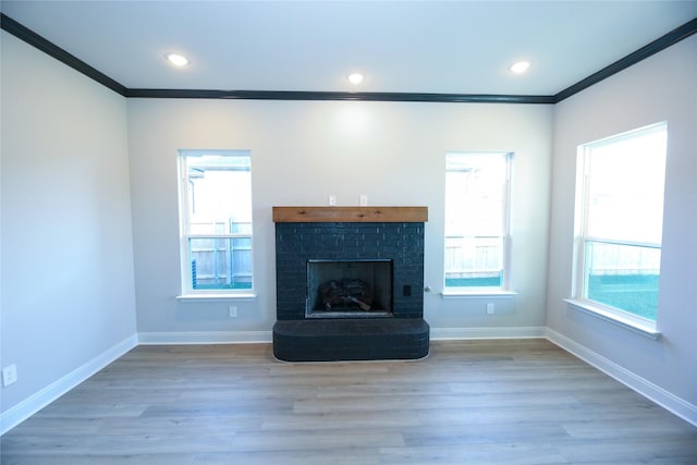1412 Mason St, Bowie, TX 76230 - unfurnished living room featuring ornamental molding, baseboards, wood finished floors, a brick fireplace, and recessed lighting