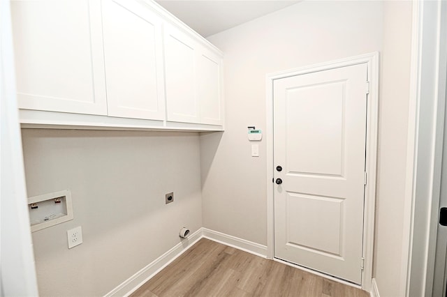 washroom with hookup for an electric dryer, hookup for a washing machine, light hardwood / wood-style flooring, and cabinets