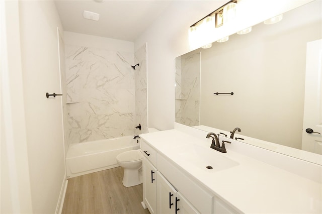 full bathroom with hardwood / wood-style floors, vanity, tiled shower / bath combo, and toilet