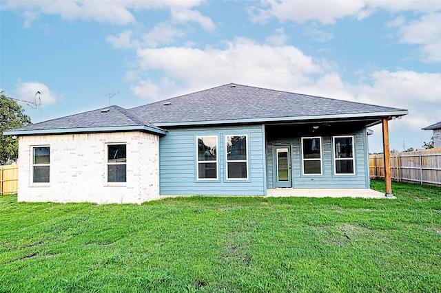 rear view of property featuring a patio area and a yard