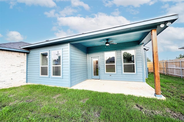 back of property with a patio area, ceiling fan, and a yard