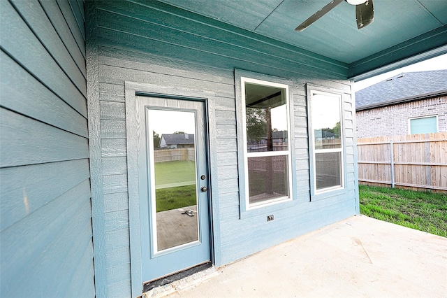 entrance to property with ceiling fan and a patio area