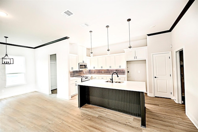 1412 Mason St, Bowie, TX 76230 - kitchen with gas range, white cabinetry, decorative backsplash, a sink, and light wood finished floors