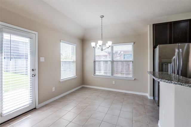 unfurnished dining area with an inviting chandelier, light tile patterned floors, and a healthy amount of sunlight