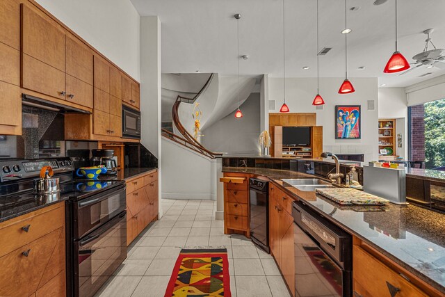 kitchen with tasteful backsplash, black appliances, sink, pendant lighting, and light tile patterned floors