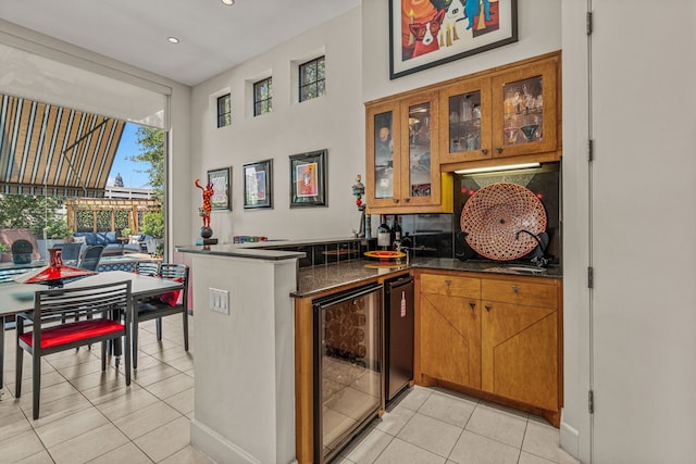 interior space featuring light tile patterned flooring, beverage cooler, and kitchen peninsula