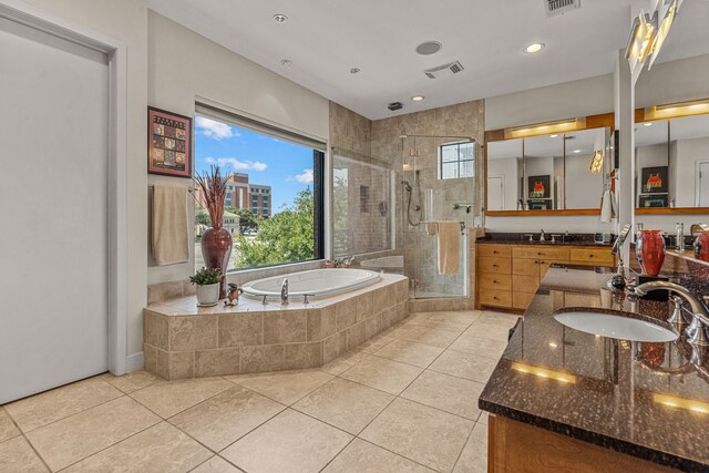 bathroom featuring independent shower and bath, tile patterned floors, a wealth of natural light, and vanity