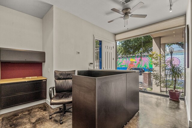 office space with concrete flooring, ceiling fan, and track lighting