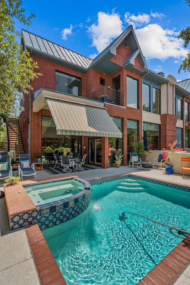 view of swimming pool featuring an in ground hot tub and a patio area