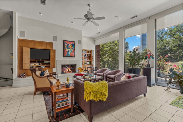 tiled living room featuring a tiled fireplace, built in features, and ceiling fan