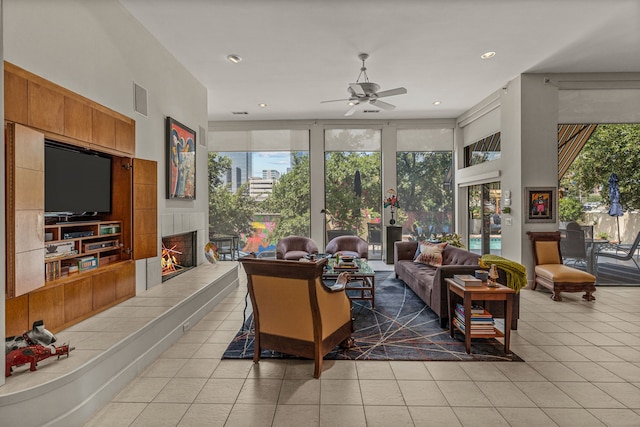 living room with plenty of natural light, tile patterned flooring, ceiling fan, and a tile fireplace