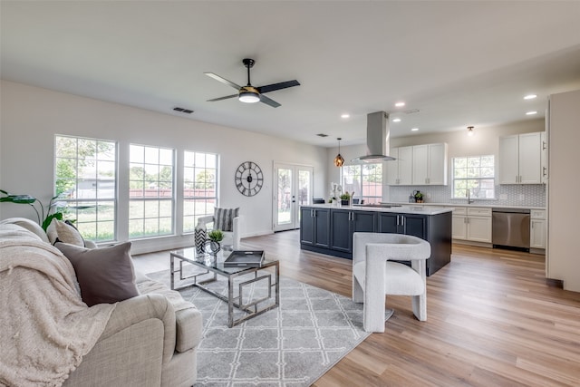 living room featuring light hardwood / wood-style floors, sink, and ceiling fan