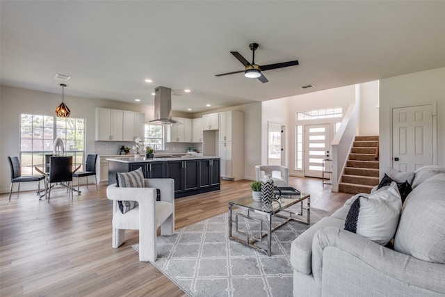 living room with light wood-type flooring and ceiling fan