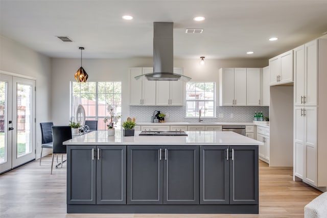 kitchen with gray cabinets, white cabinetry, a wealth of natural light, and island exhaust hood