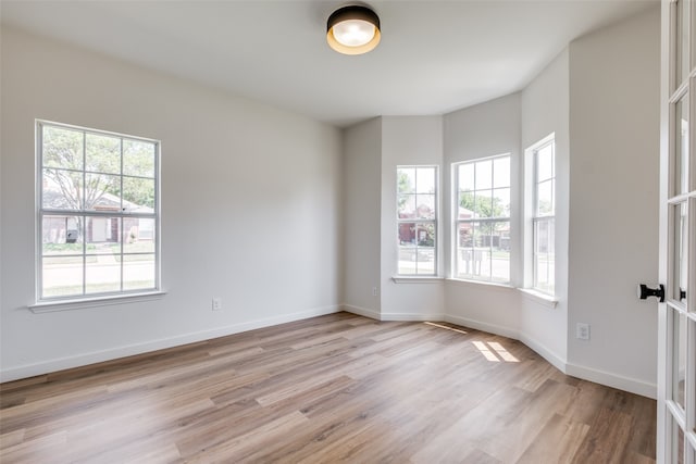 empty room featuring french doors and light wood-type flooring