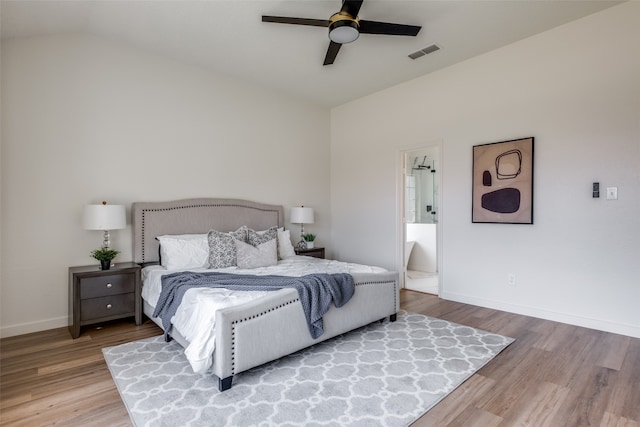 bedroom featuring lofted ceiling, ensuite bath, ceiling fan, and wood-type flooring