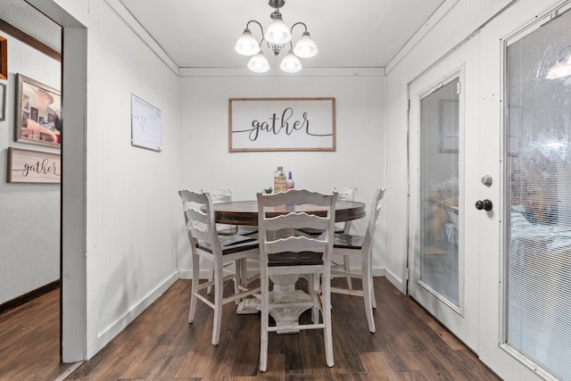 dining room with dark wood-type flooring, crown molding, and an inviting chandelier