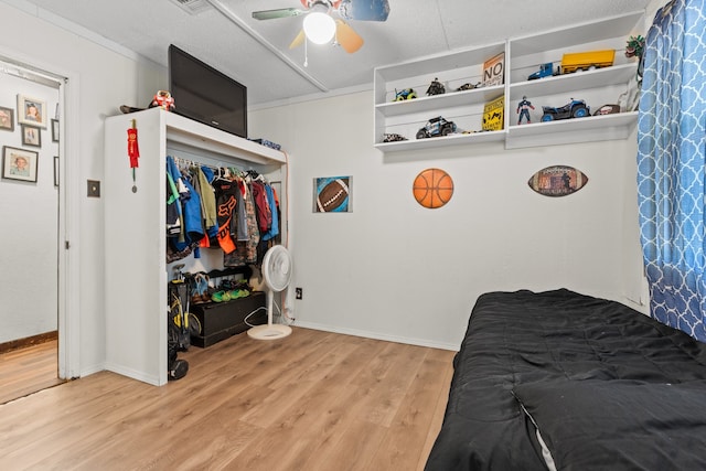 bedroom featuring a textured ceiling, light wood-type flooring, and ceiling fan