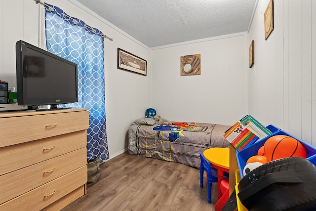 bedroom with a textured ceiling and hardwood / wood-style flooring