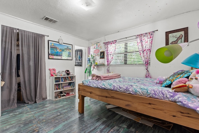 bedroom with a textured ceiling and hardwood / wood-style flooring