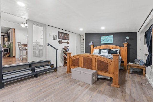 bedroom with a chandelier, wood-type flooring, and vaulted ceiling