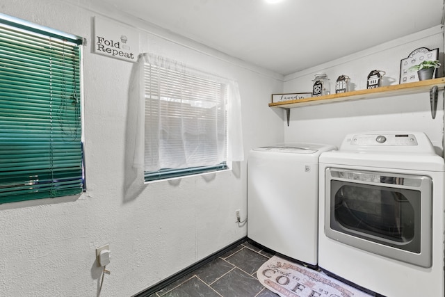 washroom featuring separate washer and dryer and dark tile patterned flooring