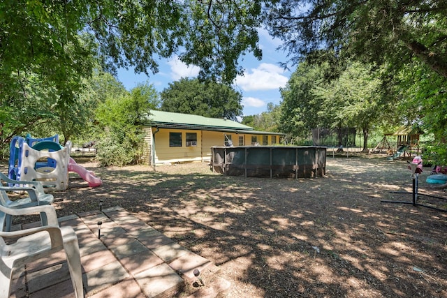 rear view of property featuring a playground