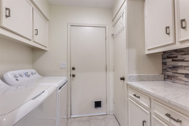 laundry area featuring cabinets, washer and dryer, and light tile patterned flooring