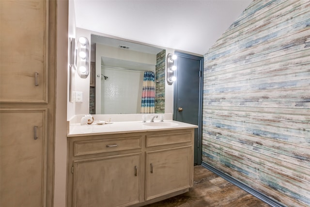 bathroom featuring curtained shower, vanity, vaulted ceiling, and wood-type flooring