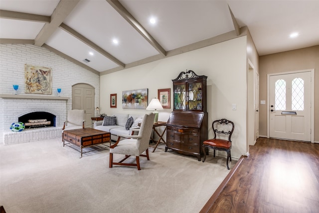 living room with a brick fireplace, wood-type flooring, and vaulted ceiling with beams