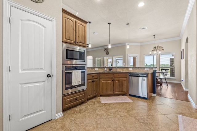 kitchen with light wood-type flooring, stainless steel appliances, stone countertops, sink, and ornamental molding