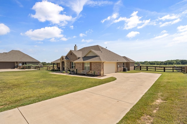 view of front of property with a garage, central AC unit, and a front yard