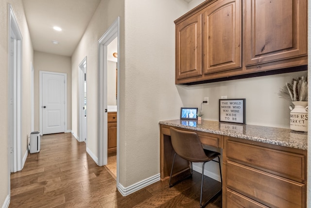 office area featuring built in desk and dark hardwood / wood-style flooring