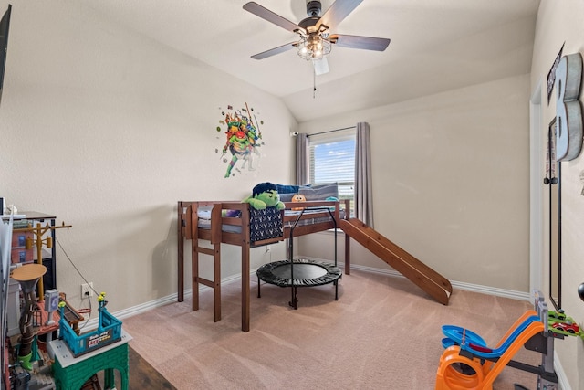 carpeted bedroom with ceiling fan and vaulted ceiling